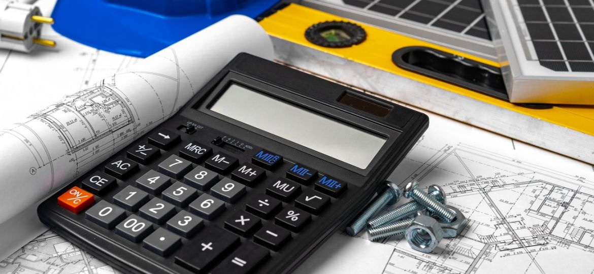 Construction blueprints, hardhat and solar battery on architect's table